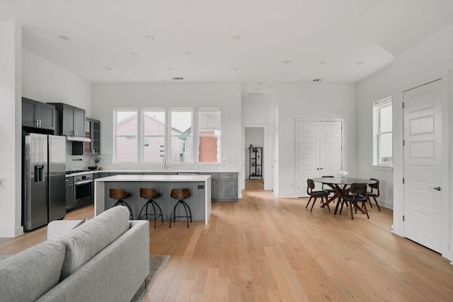 6116 Toscana Ave, Austin, TX 78724 - kitchen featuring stainless steel appliances, open floor plan, light countertops, tasteful backsplash, and light wood-type flooring
