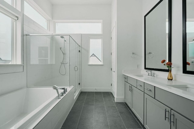 6116 Toscana Ave, Austin, TX 78724 - bathroom featuring a stall shower, a bath, baseboards, double vanity, and tile patterned floors