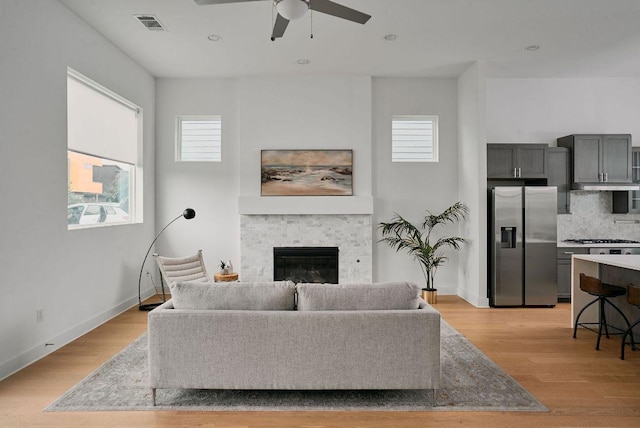 6116 Toscana Ave, Austin, TX 78724 - living room with a ceiling fan, healthy amount of natural light, a stone fireplace, light wood finished floors, and recessed lighting