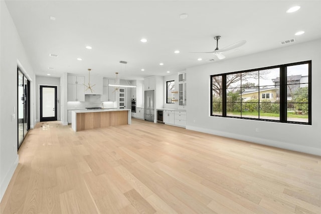1719 Piedmont Ave, Austin, TX 78757 - unfurnished living room with recessed lighting, baseboards, light wood-style floors, a ceiling fan, and wine cooler