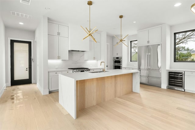 1719 Piedmont Ave, Austin, TX 78757 - kitchen with stainless steel appliances, beverage cooler, a sink, backsplash, and light countertops