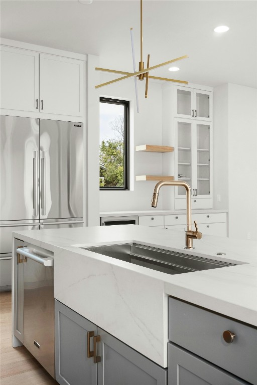 1719 Piedmont Ave, Austin, TX 78757 - kitchen with gray cabinets, a sink, recessed lighting, light stone counters, and stainless steel refrigerator