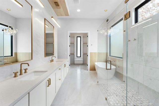 1719 Piedmont Ave, Austin, TX 78757 - full bathroom featuring a freestanding tub, double vanity, a shower stall, a wainscoted wall, and recessed lighting