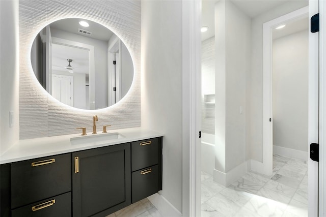 1719 Piedmont Ave, Austin, TX 78757 - bathroom with baseboards, marble look tile flooring, vanity, a ceiling fan, and tasteful backsplash