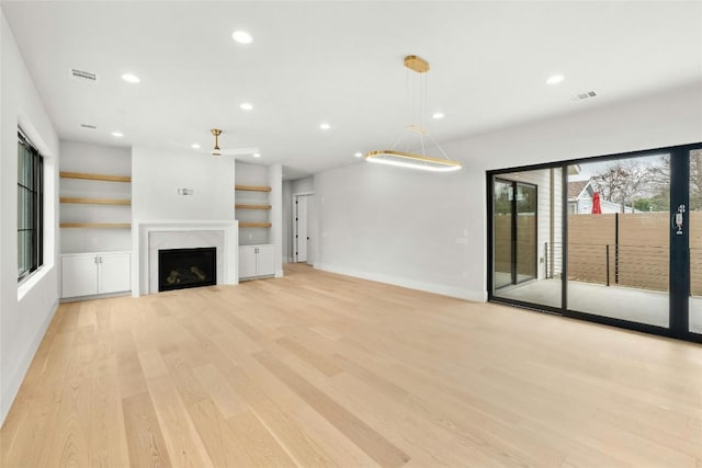 1719 Piedmont Ave, Austin, TX 78757 - unfurnished living room featuring recessed lighting, light wood-type flooring, a fireplace, a ceiling fan, and built in shelves