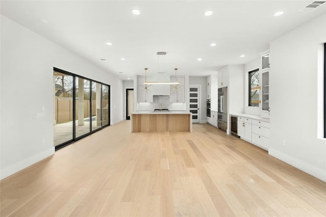 1719 Piedmont Ave, Austin, TX 78757 - kitchen with recessed lighting, light countertops, white cabinetry, light wood finished floors, and pendant lighting