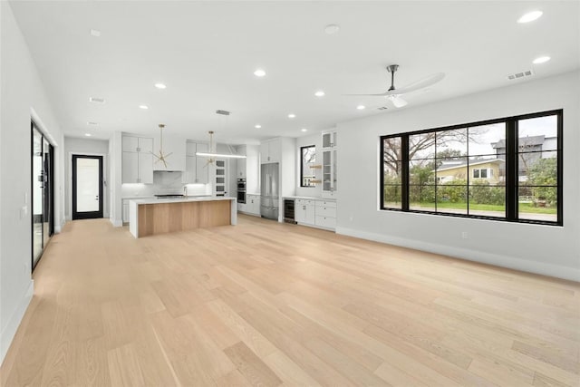 1719 Piedmont Ave, Austin, TX 78757 - unfurnished living room featuring recessed lighting, light wood-style flooring, a ceiling fan, and wine cooler