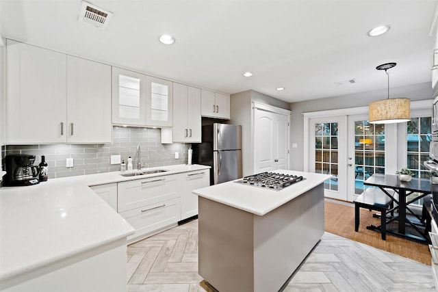 5614 Shoalwood Ave, Austin, TX 78756 - kitchen with a sink, stainless steel appliances, french doors, light countertops, and a center island