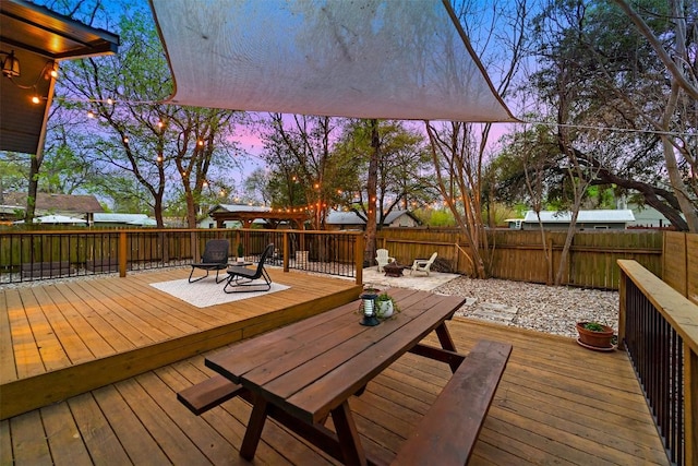 5614 Shoalwood Ave, Austin, TX 78756 - deck at dusk featuring an outdoor fire pit, fence, and outdoor dining space