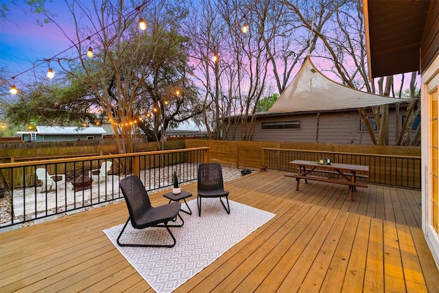 5614 Shoalwood Ave, Austin, TX 78756 - deck at dusk with a fenced backyard, outdoor dining area, and an outdoor fire pit