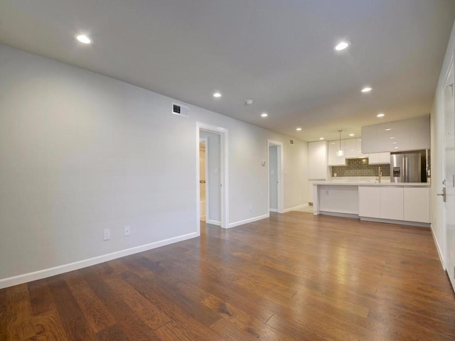 3110 Red River St Unit C-402, Austin, TX 78705 - unfurnished living room with dark wood finished floors, a sink, baseboards, and recessed lighting