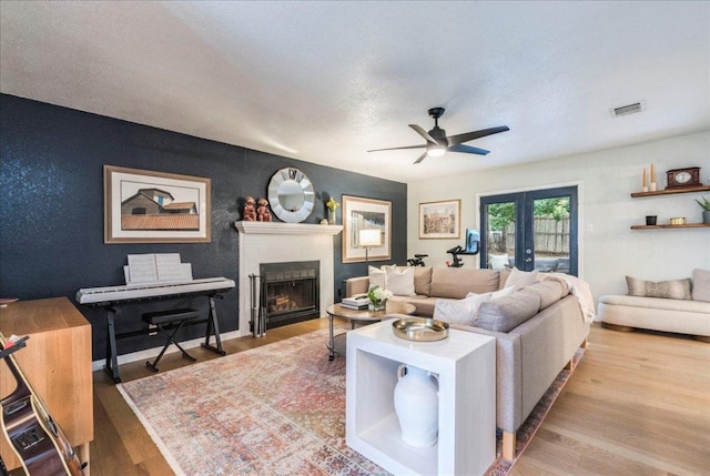 12005 Thompkins Dr, Austin, TX 78753 - living area with a ceiling fan, a fireplace, wood finished floors, and a textured ceiling
