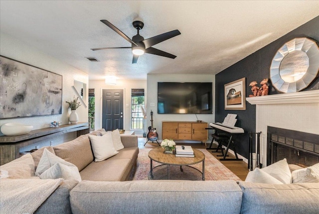 12005 Thompkins Dr, Austin, TX 78753 - living area with ceiling fan, wood finished floors, and a fireplace