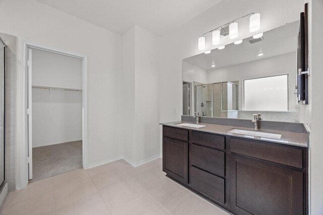 3747 Liberi Ln, Round Rock, TX 78665 - full bathroom featuring a shower stall, a walk in closet, double vanity, and tile patterned flooring