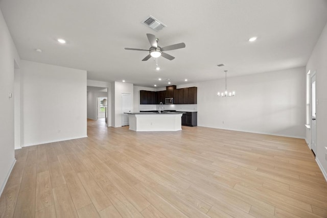 3747 Liberi Ln, Round Rock, TX 78665 - unfurnished living room with a ceiling fan, a chandelier, plenty of natural light, light wood-type flooring, and recessed lighting