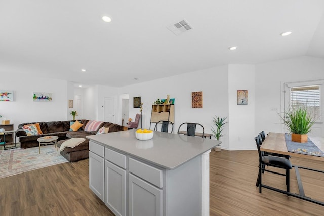 3201 Dusted Daisey St, Pflugerville, TX 78660 - kitchen with wood finished floors, a kitchen island, light countertops, recessed lighting, and open floor plan