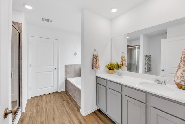 3201 Dusted Daisey St, Pflugerville, TX 78660 - full bath with double vanity, a stall shower, wood finished floors, a bath, and recessed lighting