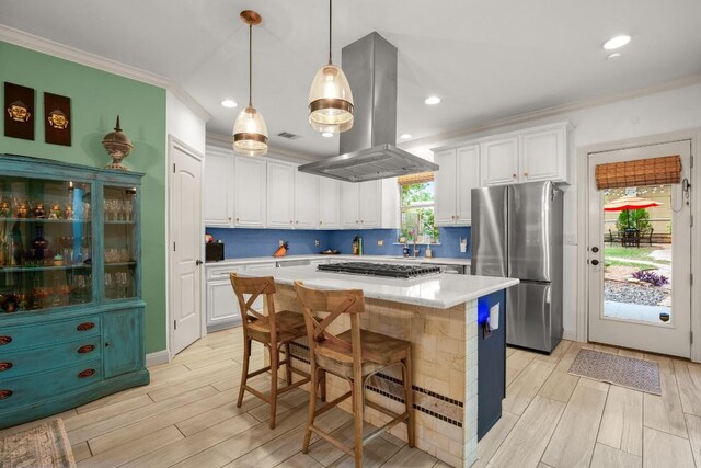 1907 Winsted Ln Unit 1, Austin, TX 78703 - kitchen featuring freestanding refrigerator, island exhaust hood, ornamental molding, light countertops, and gas stovetop