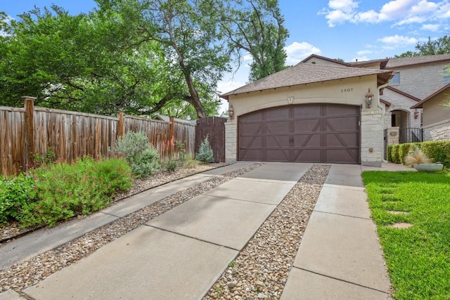 1907 Winsted Ln Unit 1, Austin, TX 78703 - view of side of property with concrete driveway, stone siding, an attached garage, and a gate