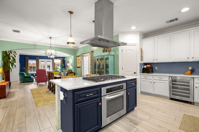 1907 Winsted Ln Unit 1, Austin, TX 78703 - kitchen with beverage cooler, stainless steel appliances, island exhaust hood, blue cabinetry, and white cabinets