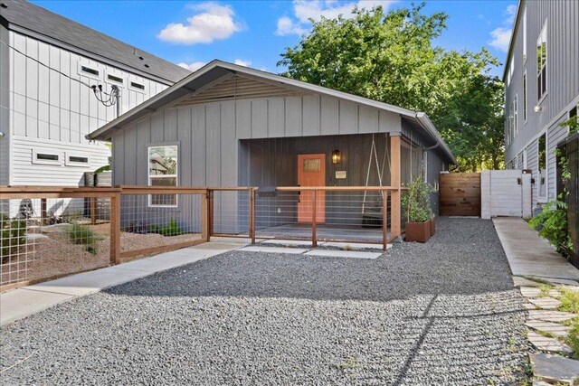 view of front of property with a gate, board and batten siding, and fence