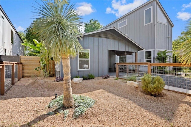 view of front of property featuring board and batten siding and a fenced backyard