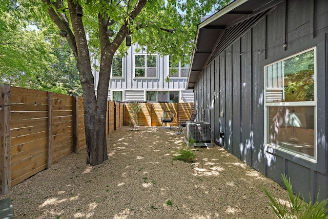 view of property exterior featuring board and batten siding, central air condition unit, and a fenced backyard