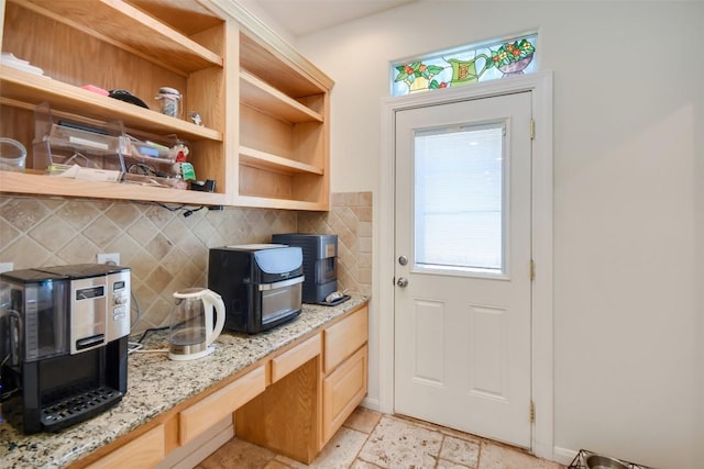 doorway to outside with plenty of natural light and light stone finish floors