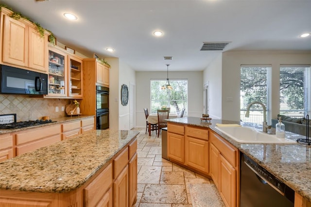 kitchen with black appliances, a sink, a center island, stone tile flooring, and decorative backsplash