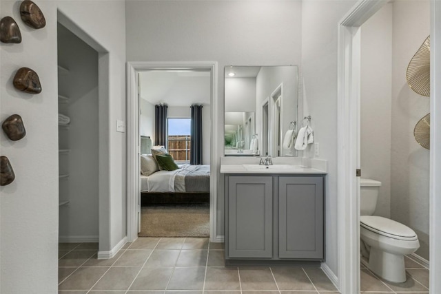 208 Hidalgo Ln, Elgin, TX 78621 - ensuite bathroom with tile patterned flooring, toilet, baseboards, and vanity
