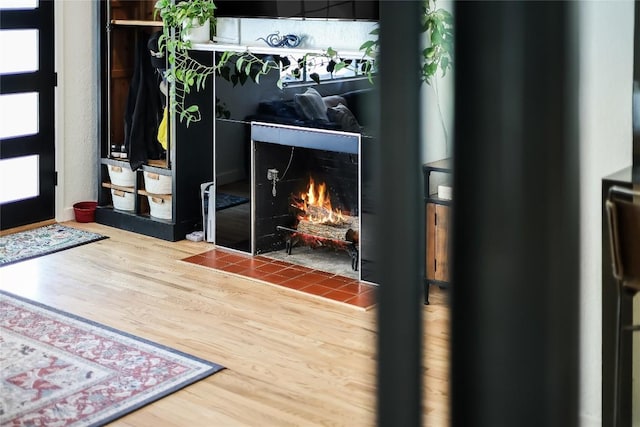 detailed view of wood finished floors and a tile fireplace