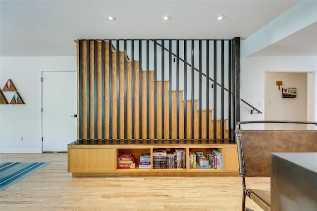 stairway with wood finished floors, recessed lighting, and baseboards