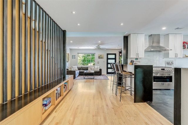 living area with light wood-style flooring, ceiling fan, and recessed lighting