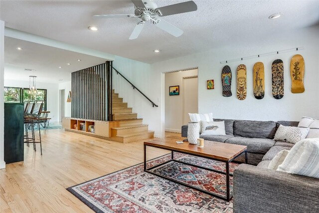 living room with light wood-style flooring, stairs, a ceiling fan, recessed lighting, and baseboards