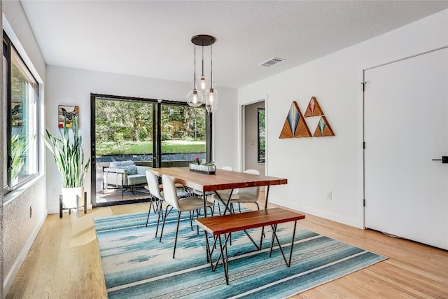 dining space with plenty of natural light, light wood-type flooring, and baseboards