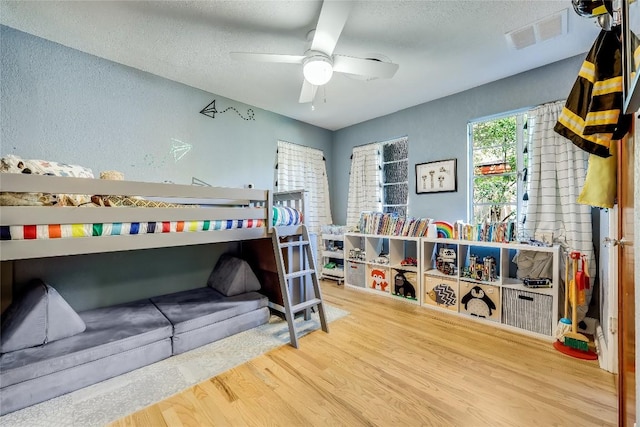 bedroom with wood finished floors and a textured ceiling