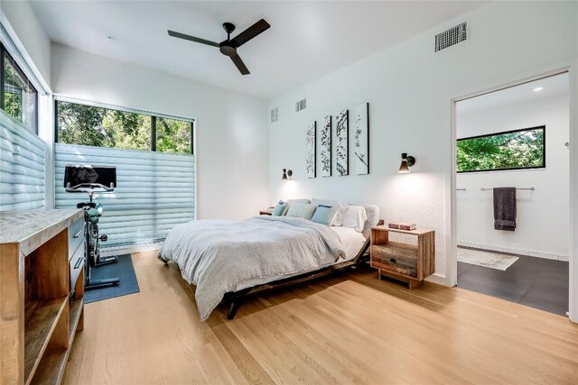 bedroom featuring multiple windows, wood finished floors, and a ceiling fan