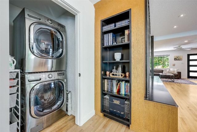 laundry room with stacked washer / dryer, wood finished floors, built in features, recessed lighting, and baseboards