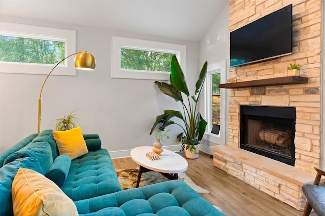 146 Caldwell Ranch Rd, Cedar Creek, TX 78612 - living area with a fireplace, plenty of natural light, vaulted ceiling, wood finished floors, and baseboards