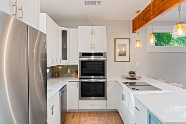 146 Caldwell Ranch Rd, Cedar Creek, TX 78612 - kitchen with stainless steel appliances, light countertops, white cabinetry, and light wood-type flooring