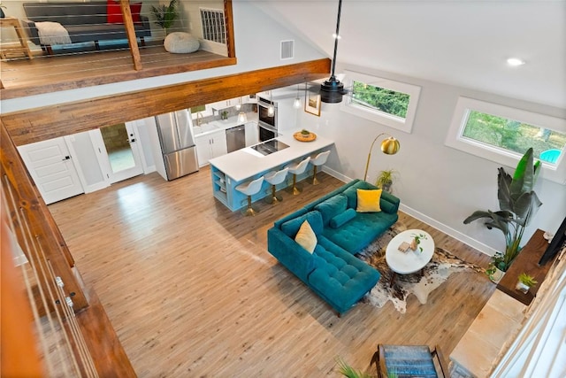 146 Caldwell Ranch Rd, Cedar Creek, TX 78612 - living area with wood finished floors, lofted ceiling, and baseboards