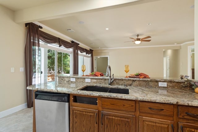 103 Nueces Trl, Georgetown, TX 78633 - kitchen with stainless steel dishwasher, a sink, light stone counters, baseboards, and brown cabinetry