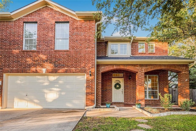traditional-style home with brick siding, a garage, and concrete driveway