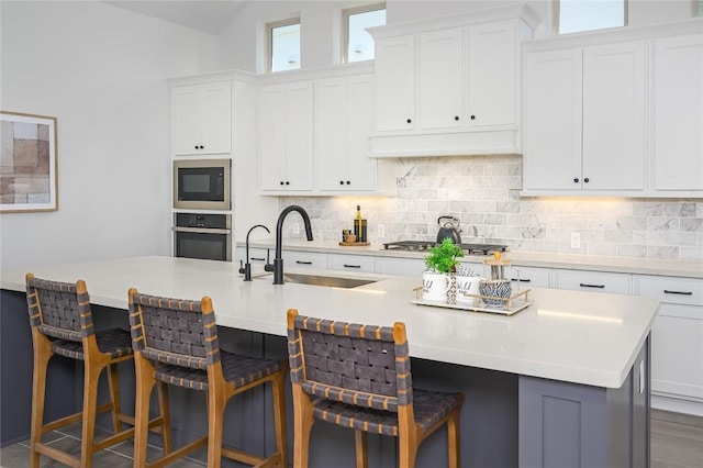6108 Antelope Well Ln, Austin, TX 78738 - kitchen featuring oven, a sink, black microwave, backsplash, and white cabinets