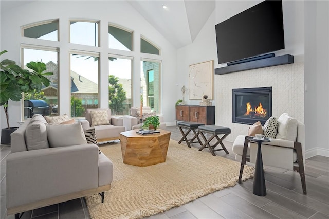 6108 Antelope Well Ln, Austin, TX 78738 - living area with wood finished floors, lofted ceiling, a glass covered fireplace, and baseboards