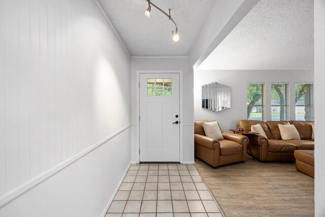 4210 Harcourt Dr, Austin, TX 78727 - foyer with plenty of natural light, a textured ceiling, rail lighting, and light wood-style floors