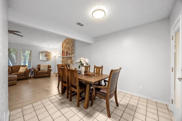 4210 Harcourt Dr, Austin, TX 78727 - dining room featuring a textured ceiling, a ceiling fan, light tile patterned floors, and baseboards