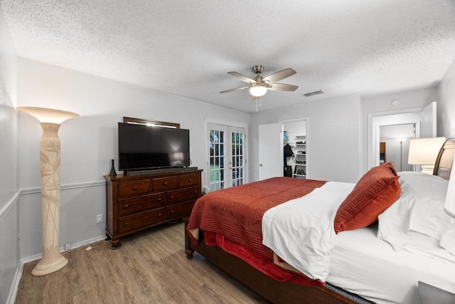 4210 Harcourt Dr, Austin, TX 78727 - bedroom with light wood-type flooring, french doors, a textured ceiling, a ceiling fan, and baseboards