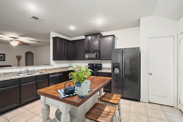 kitchen with black appliances, a sink, light tile patterned floors, ceiling fan, and dark brown cabinetry