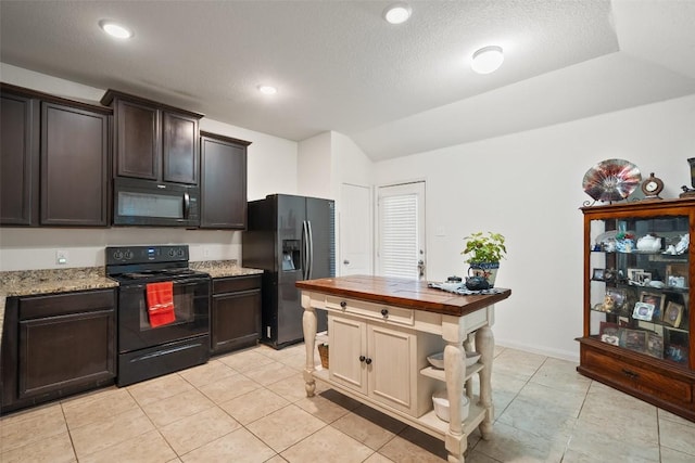 kitchen with black appliances, butcher block countertops, light tile patterned flooring, and dark brown cabinets